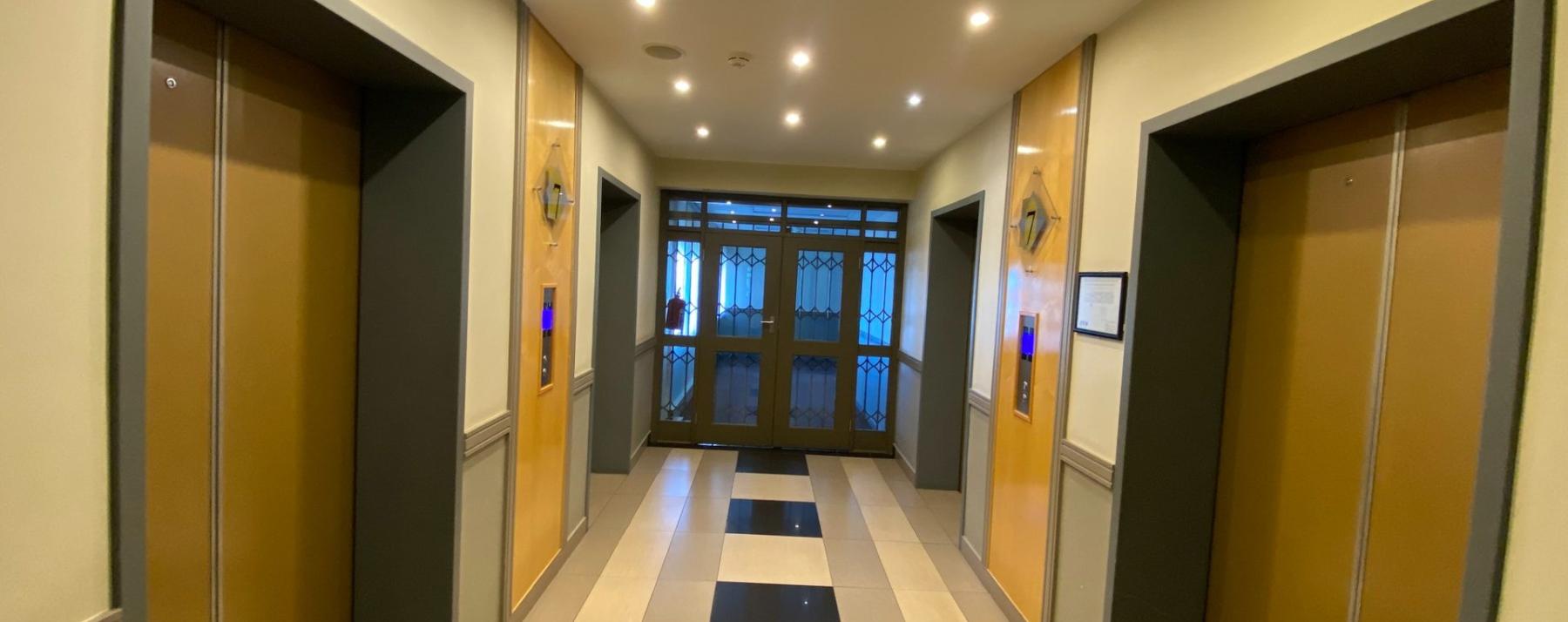Modern office lift lobby with elevators and tiled flooring
