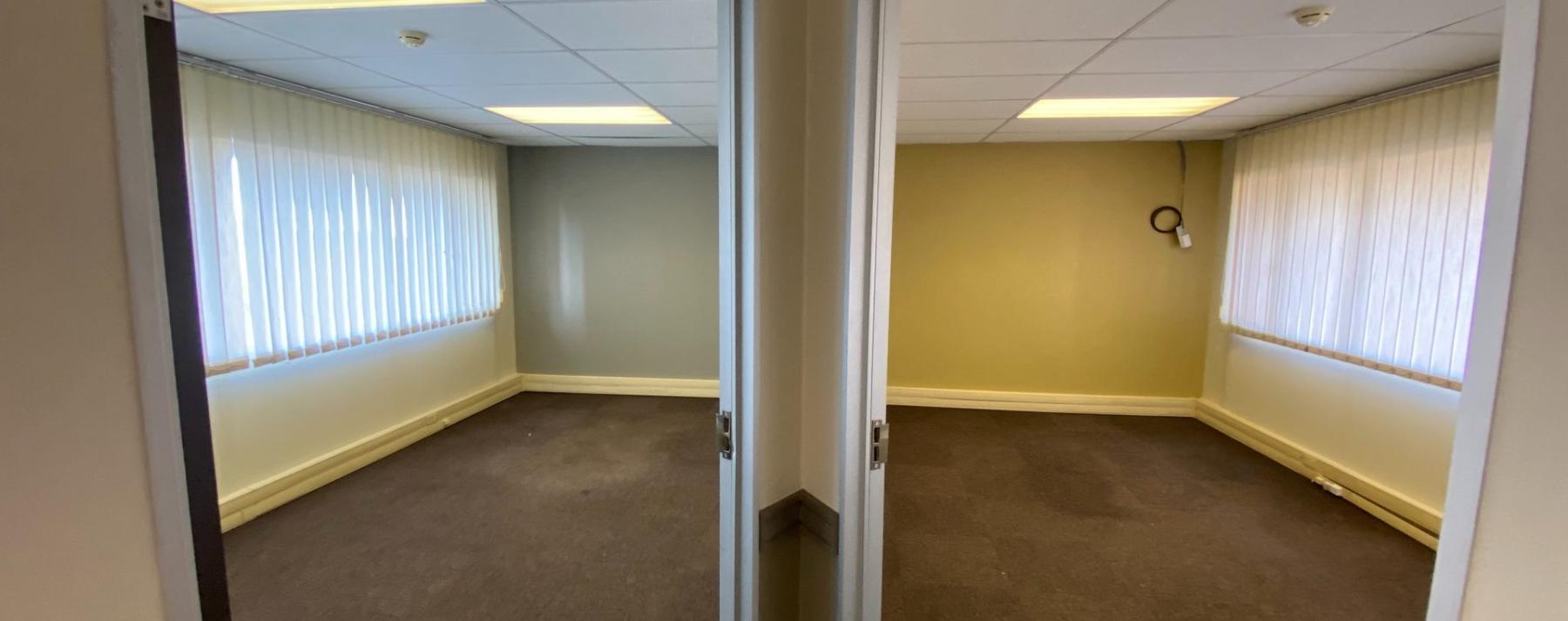 Two private office spaces with large windows and carpet flooring